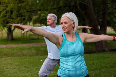 Two adults enjoying yoga outdoors